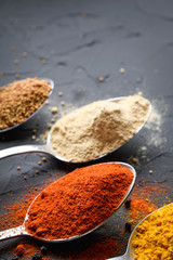 Various spices spoons on stone table.On dark concrete background.Herbs and spices on wooden table.