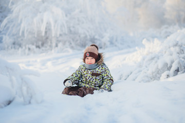Fototapeta na wymiar portrait of a five year old boy in the winter snowy forest