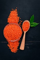 Red lentils On a wooden background. Top view. Copy space.