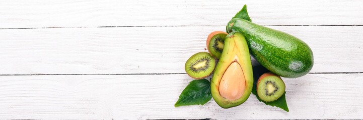 Avocado and kiwi on a wooden background. Top view. Free space for your text.