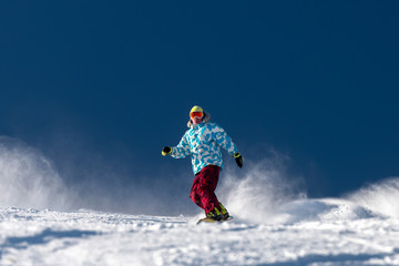 Naklejka na ściany i meble Snowboarder at ski slope against blue sky