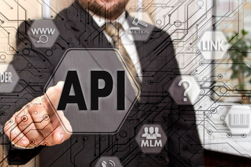 The businessman chooses the API, Application Programming Interface on a touch screen. Concept API