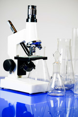 Microscope with lab glassware, science laboratory research concept