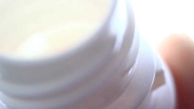 Pills in a plastic containet. Close up. Macro. Soft light from back.