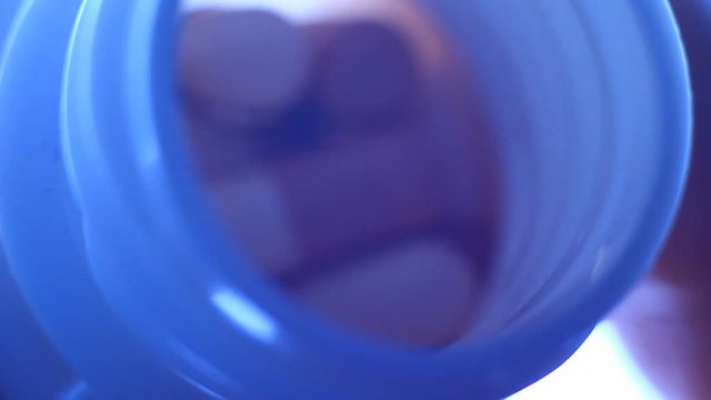 Pills in a plastic containet. Close up. Macro. Soft light from back.