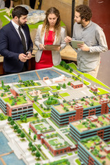 Three young urban designers discussing details of new district of the city