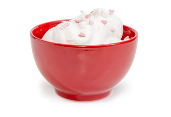 Dessert decorated with hearts confectionery strew in the red bowl