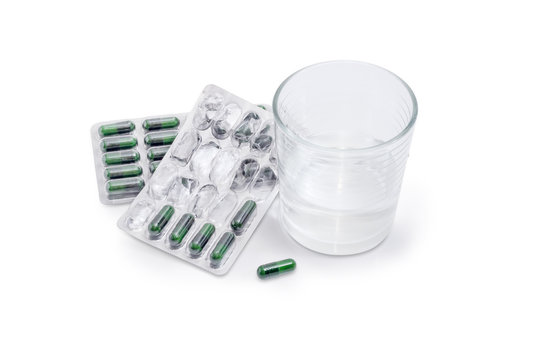 Blister packs with dietary supplements and glass of water