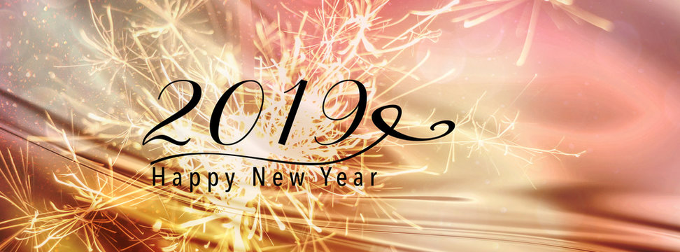 Sparklers on a gold and pink abstract backdrop with silk fabric. Happy New Year 2019 quote. Perfect for social media campaigns. Panoramic banner style. Scales down to fit a facebook header size. 