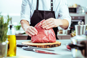 Koch in der Küche mit großem stück Steak Fleisch