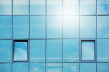 sky and clouds reflected in the windows of a modern office building, glass building