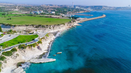 Aerial view of coastline and landmark big white chalk rock at Governor's beach,Limassol, Cyprus. Steep stone cliffs and deep blue sea waves next to Kalymnos fish restaurant and vasilikos power station