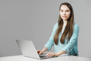 Young woman sits at laptop involved in work