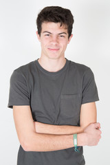 Photo of adorable young happy boy wearing gray shirt looking at camera over grey background