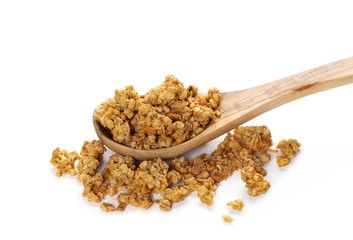 Crunchy granola, muesli pile in wooden spoon with peanuts isolated on white background
