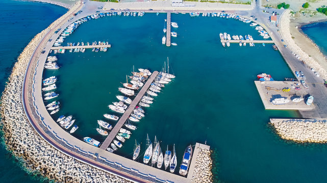 Aerial Bird's Eye View Of Zygi Fishing Village Port, Larnaca, Cyprus. The Fish Boats Moored In The Harbour With Docked Yachts And Skyline Of The Town Near Limassol From Above. 