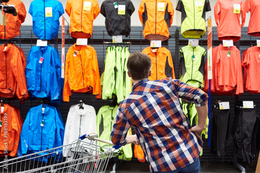 Sticker Man chooses sports clothes in store