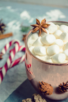 Hot chocolate with marshmallows, cinnamon and anise, served with christmas decoration. Selective focus. Toned image.