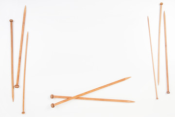 Wooden knitting needles frame with copy space for text on white background