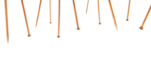 Knitting banner background. Wooden bamboo knitting needles on white background