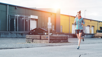 Young sporty woman jogging alone in the urban area