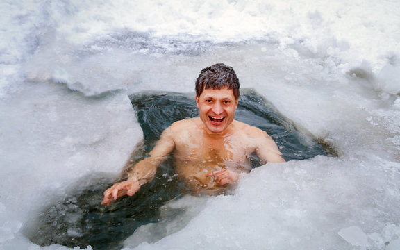 A Man Is Swimming In An Ice Hole In The Winter