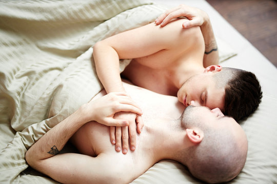 One of homosexual partners sleeping on shoulder of his sweetheart under blanket