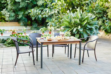 Served table with healthy organic food ready for guests in garden-room