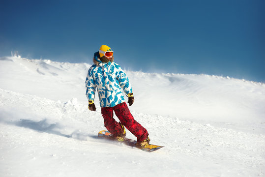 Snowboarder downhill at ski slope