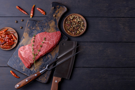 Raw beef steak with thyme and pepper