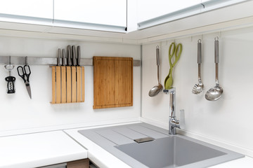 white glossy kitchen interior design with hanging utensils