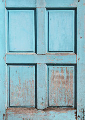 Wooden shutter with cracked paint of blue color