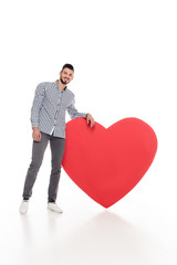 handsome man leaning on big heart on white, valentines day concept