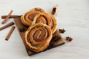 Three buns with cinnamon on white background (close-up)