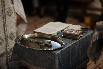 Priest, Bible and Cross in church