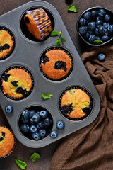 Homemade vanilla muffins with blueberries on a dark concrete background.Rustic!