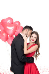 boyfriend with heart shaped balloons hugging girlfriend isolated on white, valentines day concept