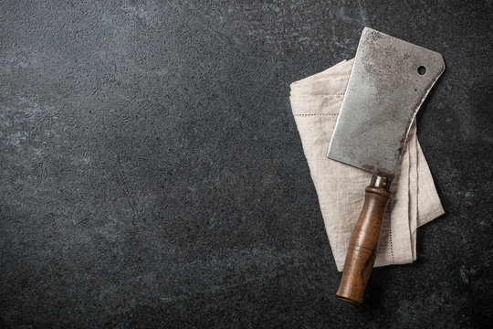 Vintage meat knife and kitchen towel on blackboard