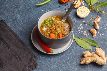 Indian vegetarian lentil soup, mung dal. Indian food spice concept. Dark background, top view. Vegan Healthy Food Concept.