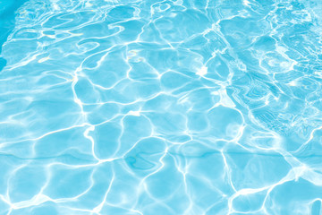 Fototapeta na wymiar Blue and bright water surface with sunreflection in swimming pool