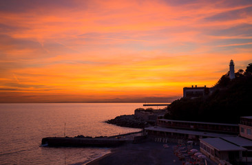 Naklejka na ściany i meble Beautiful and colorful sunset in Genoa (Genova), Ligurian coast, Mediterranean sea, Italy