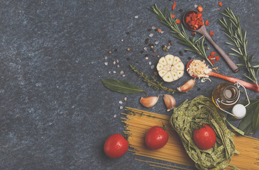 Selection of spices, pasta,  herbs and greens. Ingredients for cooking pasta. Dark background, top view, copy space.
