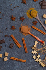 Selection of sugar, chocolate, spices, cocoa powder. Ingredients for cooking cocoa. Dark background, top view, copy space. Winter beverage concept.
