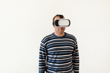 Man wearing and playing mobile game app on device virtual reality glasses on white background. Man action and using in virtual headset, VR box for use with smart phone. Contemporary technology concept