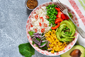 Plate with salad, corn, avocado and rice on a concrete background!