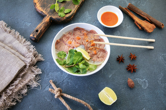Vietnamese soup on a textured table with objects