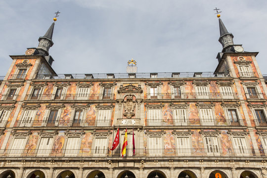Detail of a decorated facade with traditional windows and balconies at the Palza Mayor, Madrid, Spain.