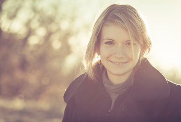 Young fashionable happy blonde woman posing  on the field landscape. Concept Love and Emotions. Toned Image.