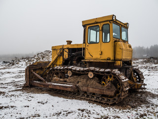 old yellow bulldozer at winter in workplace