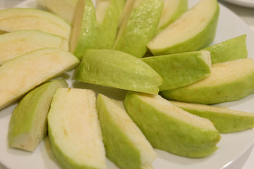 Sliced guava arranged in white dish plate ready to serve